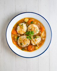 Stewed hake medallions with vegetables. Top view table with  decorations.