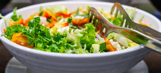 Salad of tomatoes, bell peppers and green lettuce leaves. Healthy eating concept