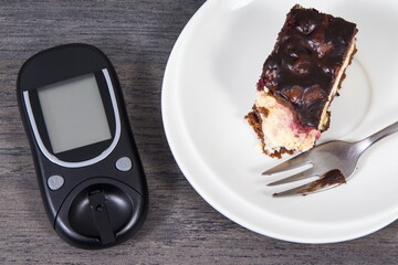 Glucose meter for measuring sugar level and cheesecake with cherries and chocolate. Nutrition during diabetes