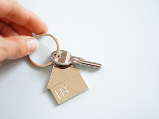 hand holding key and key ring of a house