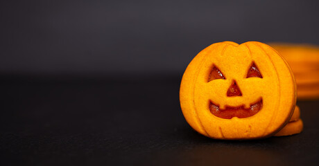 Close-up Pumpkin Cookies for Halloween on Dark Background with Copy Space.