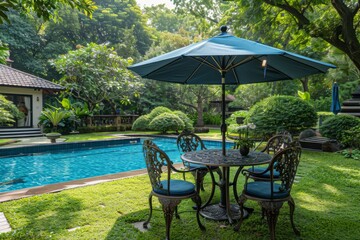 Obraz premium High-Quality Outdoor Patio Dining Set with Umbrella Near Swimming Pool on Grass