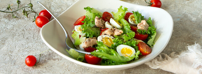 bowl of salad with cod liver, quail eggs and cherry tomatoes on the table