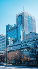 Obraz premium A modern office building with sleek glass facades and clear blue sky, representing urban architecture and contemporary design.