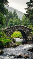 Fototapeta premium A picturesque stone bridge spans a serene river, surrounded by lush greenery and majestic mountains in a tranquil landscape.