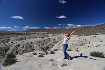 Altai Republic. Tourists pose against the background of Martian and Moon landscapes – deserted area with canyons.