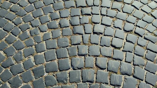 background of black cobbled stone road. Black or dark grey stone pavement texture. Ancient paving stone background