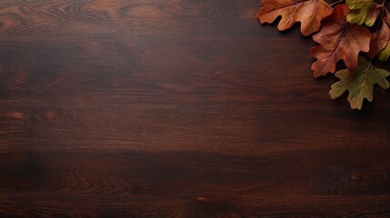 A collection of scattered oak leaves rests on a dark wooden surface, illuminated by soft natural lighting that enhances the warm autumnal tones and textures, offering ample copy space