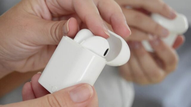 Woman take out of case modern wireless headphones for listening music or talking. Close-up.