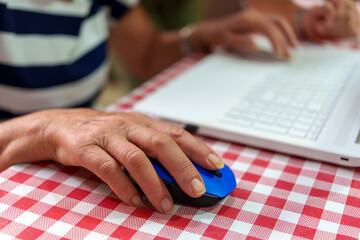 Elderly Woman’s Hand Using a Laptop to Overcome the Digital Divide
