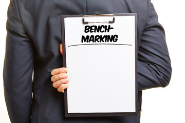 Geschäftsmann halt Klemmbrett mit Überschrift Benchmarking
