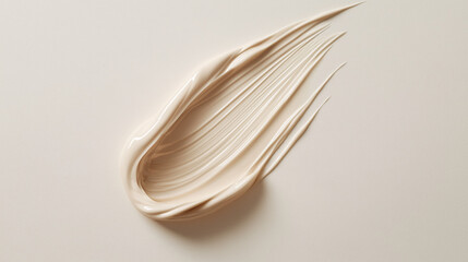 a luxurious swatch of light beige concealer on a flawless white canvas