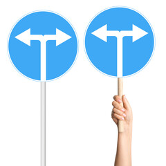 Set of sign with arrows left and right in hand and on pole. For direction or decisions.