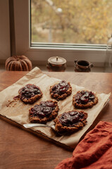 Home made seasonal plum pies or tarts with oatmeal crust aesthetic seasonal  moodyy lifestyle autumn usg shot with pumpkin decoration back light