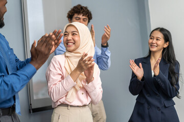 Diverse group business in formal attire smiling and clapping during a corporate meeting, celebrating success and achievements, diverse workplace environment with professional women engaged in teamwork