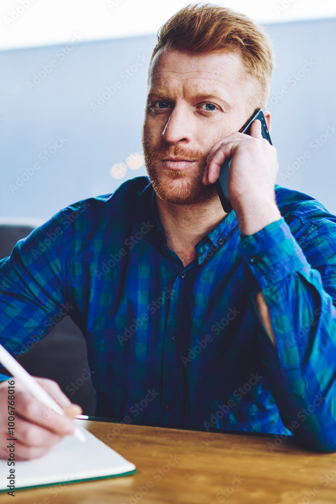 Aufkleber portrait of serious hipster guy looking at camera while calling to operator for checking account bal