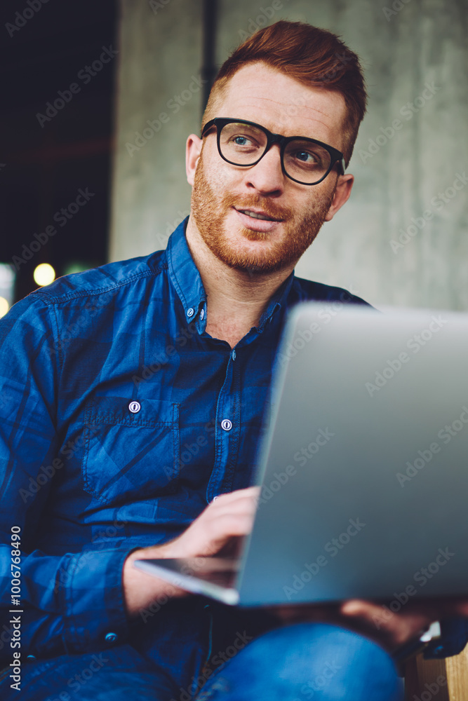 Poster thoughtful hipster guy in optical spectacles for provide eyes protection looking away while waiting 