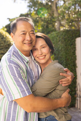 Obraz premium Smiling couple embracing outdoors, enjoying quality time together in garden
