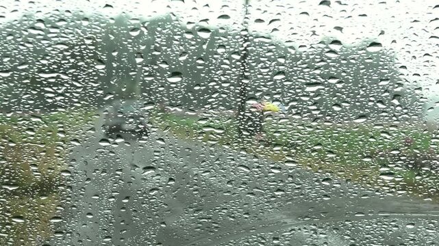 Outside view from inside of a car through the windscreen on a rainy day