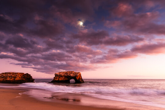 Natural Bridges at sunset with dramatic clouds and waves