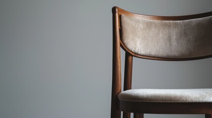 Close-up of a bespoke wooden dining chair with velvet upholstery capturing the fine craftsmanship against a neutral background, creating ample space for text