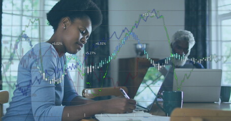 Image of financial data processing over african american woman using laptop