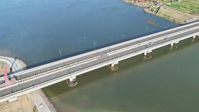 Aerial view of cars are crossing on the bridge of big river. Kretek II bridge, Opak River, Yogyakarta, Indonesia.