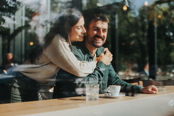 Couple enjoying a warm afternoon together in a cozy cafe, sharing smiles and laughter over coffee while seated by a large window