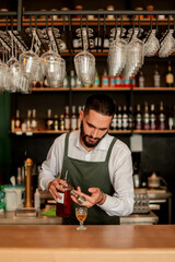 Skilled bartender prepares a cocktail at a stylish bar during a vibrant evening in a bustling city