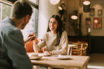 A joyful conversation over coffee and dessert in a cozy café during a sunny afternoon