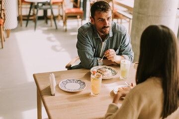 A delightful afternoon dessert experience at a cozy cafe shared between two friends enjoying delicious treats and refreshing drinks