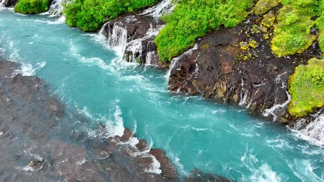 Blue glacial river with many small waterfalls, Stunning bird's eye view, Cold turquoise glacial river with many streams in summer season, Iceland, Hraunfossar and Barnafoss