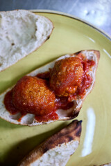 A hearty sandwich made with a pizza dough base, baked to perfection and filled with two perfectly assembled meatballs