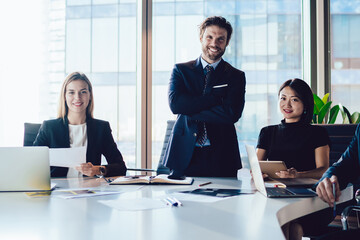 Portrait of cheerful male and female entrepreneurs collaborating in team. successful professional colleagues posing at camera in spacious office interior, successful group of business people smiling