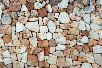 Textured old stone block wall. Front view. Abstract brown rock background