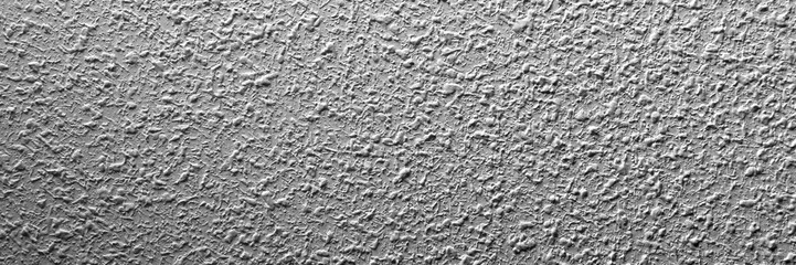 Grainy plastered cement white wall in shade. Textured gray empty poster. Copy space