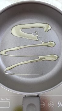 The act of pouring oil on a hot non stick frying pan