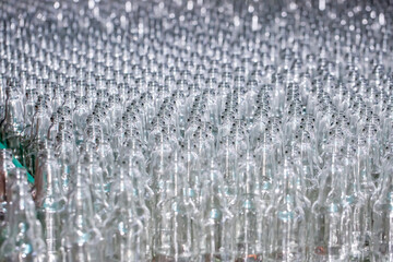 Glass factory, production of glass containers. Molten glass is blown into molds. Robotics in industry. Modern technologies, robotic machines produce products. Technological work at the plant.