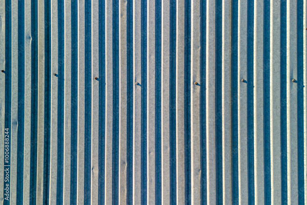 Poster aerial view of textured vertical lines on a metal surface, showcasing intricate patterns and shadows