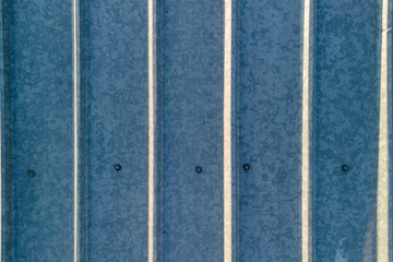 Aerial view of corrugated metal sheets with lines of shadow and texture variation. Modern...