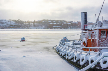 A cold winter morning in Stockholm with snow and ice on islands and boats