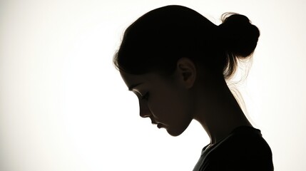 The silhouette of a girl with her head slightly tilted, hands in pockets, providing a calm and reflective pose on a stark white backdrop