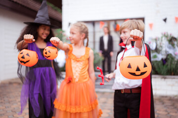 Children in ghost costumes are having fun trick-or-treating on Halloween