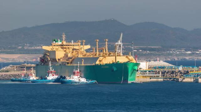 LNG (Liquified Natural Gas) tanker anchored in port terminal timelapse, tanks for storage. Oil Crude Gas Ship. LPG at Bay Petroleum Chemical or Methane freighter export import transportation. Sines