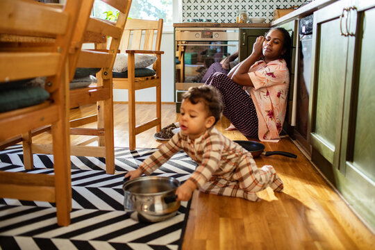 Mother playing with toddler in the kitchen during morning