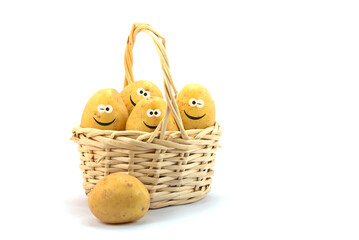 Potatoes with a funny face in a basket against a white background