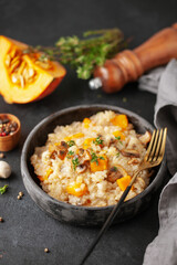 Pumpkin mushrooms risotto with fresh thyme in ceramic bowl. Italian Cuisine.