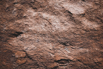 Brown rough stone wall for abstract background and texture for interior or exterior design. Beautiful patterns, space for work, banner, wallpaper close up.