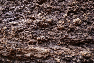 Brown rough stone wall for abstract background and texture for interior or exterior design. Beautiful patterns, space for work, banner, wallpaper close up.