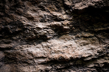 Brown rough stone wall for abstract background and texture for interior or exterior design. Beautiful patterns, space for work, banner, wallpaper close up.
